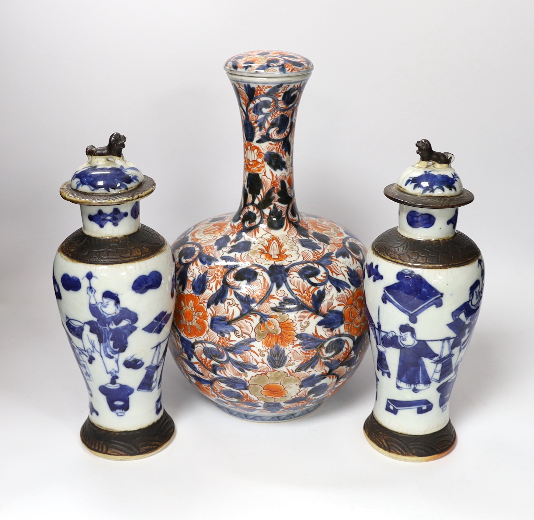 A pair of Chinese blue and white crackleware vases and covers and an Imari vase and cover, largest 31cm high